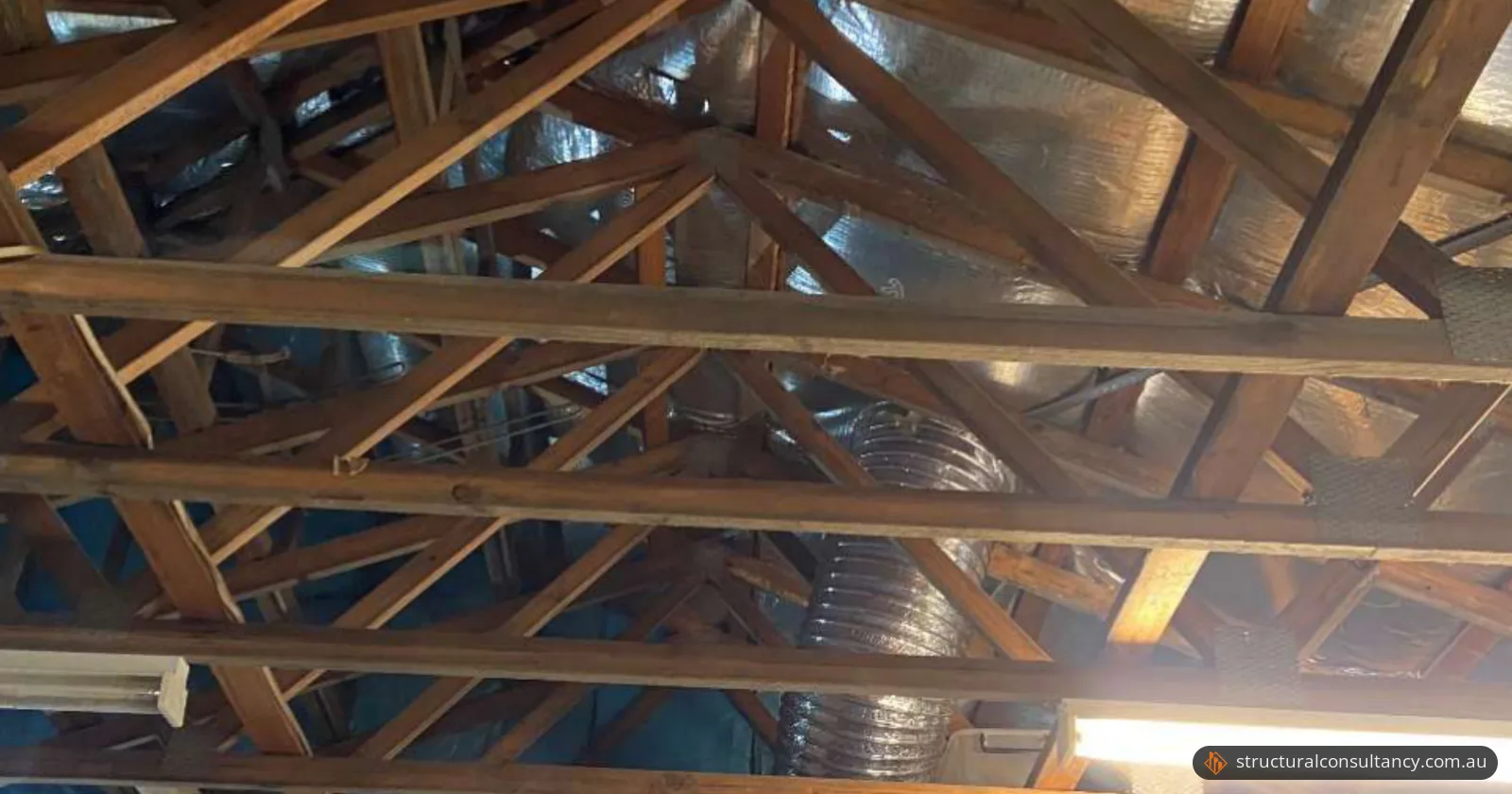 Exposed timber roof trusses and ducting in a house under renovation